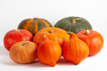 Close up Assortment of fresh orange and green pumpkins on a white background. Autumn harvest...