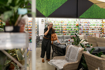 Shopping for home decor at a garden and furniture store during the day while touching her face...