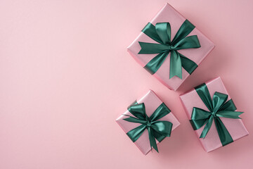 Elegant pink presents featuring green bows, displayed on a soft pastel backdrop. Perfect for...
