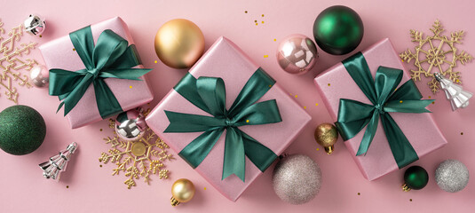 Festively wrapped pink gift boxes with green bows surrounded by Christmas ornaments and snowflakes