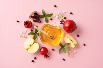 Festive arrangement featuring apples, honey in a decorative bowl, and pomegranates symbolizing...