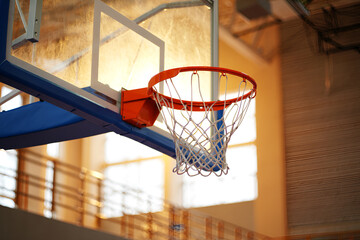 Orange basketball hoop with white net and blue padding image