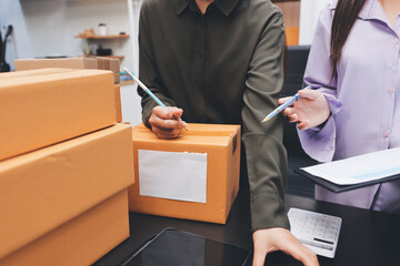 Portrait of Starting small businesses SME owners, two Asian woman check online orders Selling products working with boxs freelance work at home office, sme business online small medium enterprise
