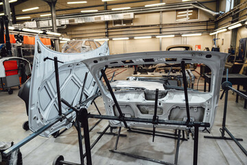 Various parts of the car on the stands for painting. Repairing car body work after the accident by...