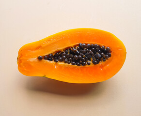 open papaya with seeds on a light beige background