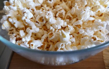 Homemade popcorn in a big glass bowl in the kitchen