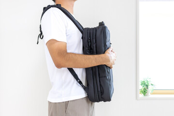ビジネスリュックを前掛けする男性（顔無し、30代、日本人）