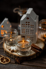 Aromatic christmas handmade candle with the sweet scent of gingerbread cookies. Cozy holiday home atmosphere, aromatherapy. Interior composition with burning candles, anise, cinnamon, pine cones