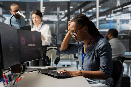 Server farm employee trying to fix compromised equipment after hacker attack. Engineer in data center disturbed by malicious threat alert, initiating protocol to protect critical systems