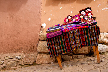 Colorful Handmade Textiles and Dolls on Rustic Street Table
