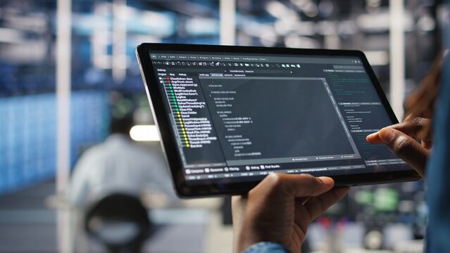 Close up of server room programmer checking coding on tablet enhancing operational efficiency and reducing downtime. Developer verifying programming language script used to update gear, camera A