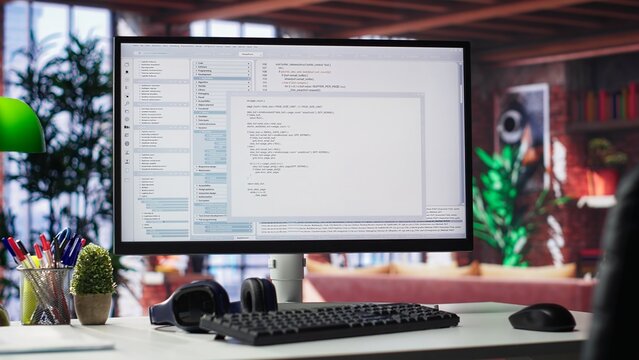 Home office with PC running terminal window for programming code. Designed for IT professionals, the space offers comfort for working on user interface, debugging and algorithm scripts.