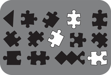 Fototapeta premium Collection of black and white puzzle pieces and shapes arranged on a gray background symbolizing connection and completion