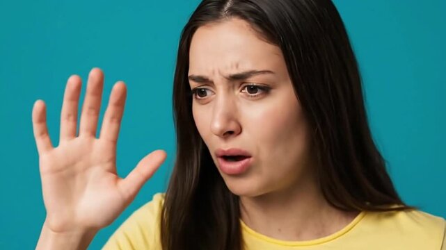 Woman with a disgusted expression holding up her hand