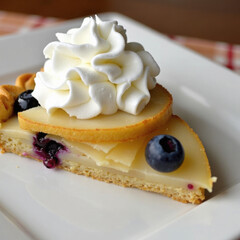 Delicious Slice of Blueberry Cream Dessert with Whipped Topping on a White Plate