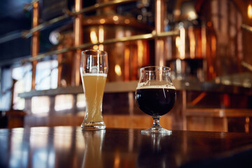 Two cold glasses of beer are comfortably sitting on a bar counter