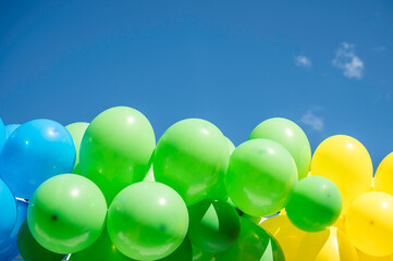 pastel coloured balloons against a blue sky