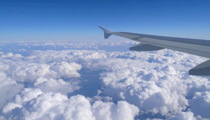 Obraz premium Airplane wing view above clouds with travel, and blue sky background.