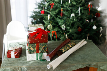 Pile of stylish christmas gifts with ribbon and ornaments on background of decorated beautiful...