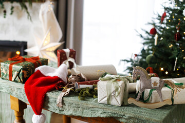 Merry Christmas and Happy Holidays! Stylish christmas gifts, ribbon, santa hat, vintage toy and...