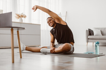 Online Training. Cheerful Black Man Doing Side Bend Stretching Exercise At Laptop Computer Sitting...