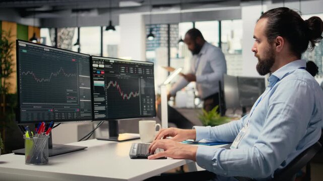 Day trader analyzes stock market trends and price candlestick charts, making buy and sell decisions in office. Professional stockbroker places client orders using trading software, camera A