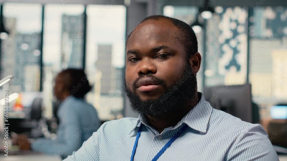 Poster smiling portfolio manager at computer desk evaluates assets based on statistics and economic indicat