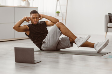 Sporty African American Guy Doing Elbow To Knee Abs Crunches Flexing Abdominal Muscles Exercising...