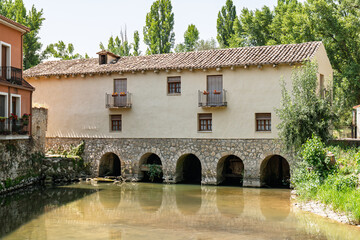 Peñafiel, Valladolid, Spain – View of an old building over the river crossing the town,...