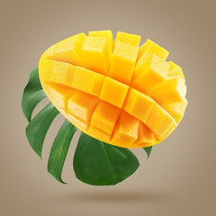 mango fruit with leaf on a light brown background.