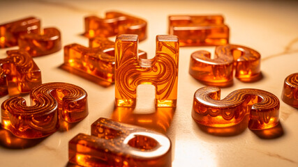 Glossy amber resin letters on warm marble surface