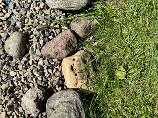  Natural stones on lush green grass creating textured outdoor background 