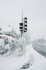 view of a frozen red light on the corner of a street during a snow storm