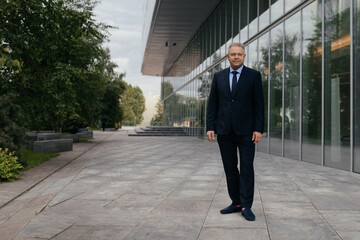 Mature man in suit with blue shirt and tie on urban city background