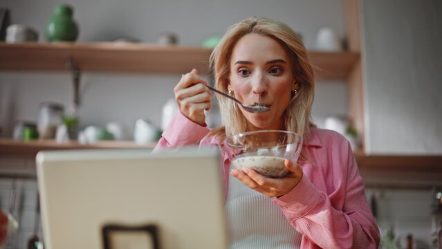 Morning woman eating cornflakes watching tablet kitchen closeup. Girl breakfast