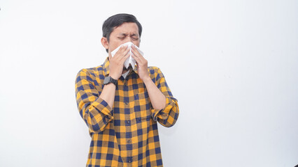Asian young man cover his nose and mouth with tissue when sneezing