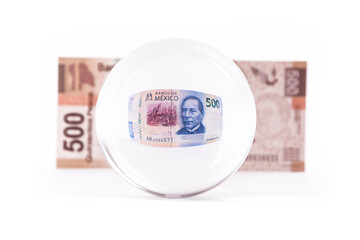 bola de cristal con billete mexicano de 500 pesos mexicanos al fondo se ve un billete de pesos...