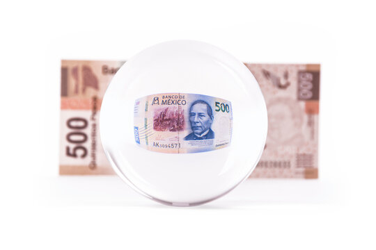 bola de cristal con billete mexicano de 500 pesos mexicanos al fondo se ve un billete de pesos mexicanos antiguo