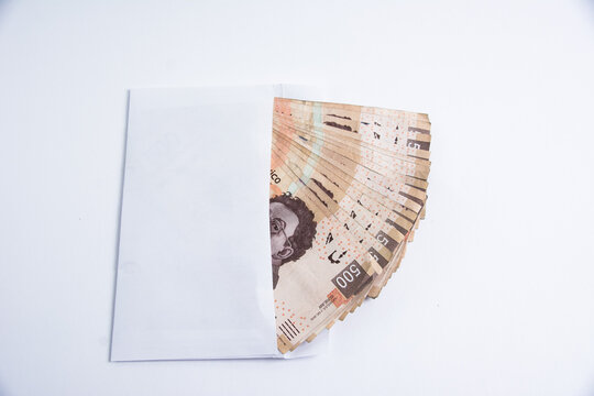BILLETES MEXICANOS DE 500 PESOS DENTRO DE UN SOBRE BLANCO SOBRE FONDO BLANCO, VISTO DESDE ARRIBA