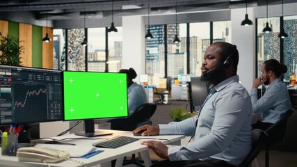 Financial advisor using green screen computer offers investment guidance during client calls. African american man talking in headset mic, helping customers build portfolio using mockup PC, camera A - Powered by Adobe