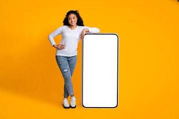 Cool Mobile App. Cheerful Black Woman Leaning At Big Smartphone With Blank White Screen,...