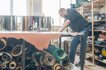 Caucasian bearded man working as a tanner in a workshop. 