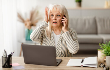 Portrait Of Shocked Mature Woman Talking On Smartphone Grabbing Head In Amazement And Surprise,...