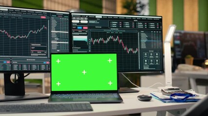 Stock market metrics diagrams displayed on green screen laptop in prop firm office. Workstation in forex company workspace with live financial data visible on mockup notebook - Powered by Adobe
