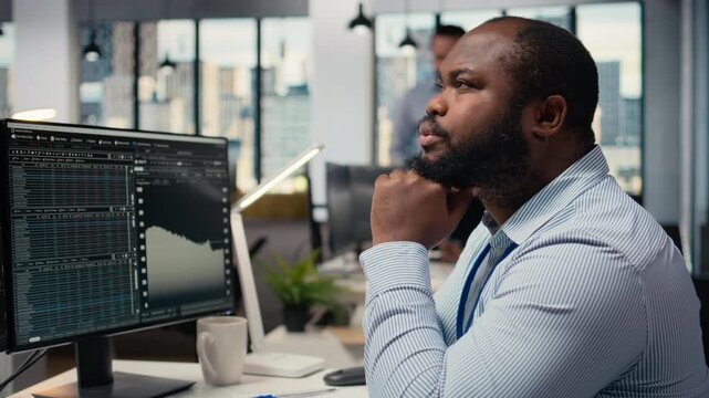Close up of trader daydreaming, visualizing becoming rich after stock market speculations. African american man in prop firm office lost in thought, picturing prosperous trade, camera A