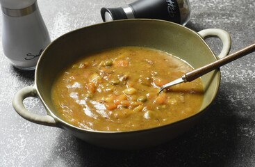 Beef and vegetable soup in a bowl. Meat with potatoes, carrots, peas, onions, garlic and tomatoes.
