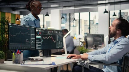 Portfolio manager in wheelchair and coworkers analyze stock market to enhance investment returns. Man with disability and colleagues in inclusive office identify investment opportunities, camera A - Powered by Adobe