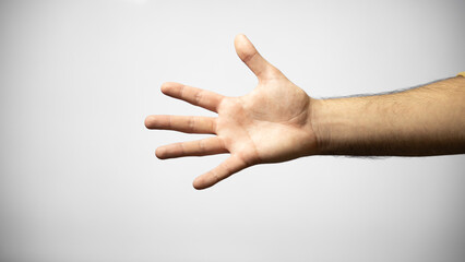 Hand of a Caucasian man making a hand gesture meaning number five, isolated on white background