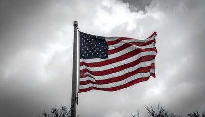 American flag waving in a cloudy sky.