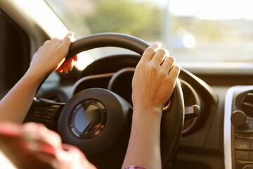 Woman behind steering wheel of modern car, closeup